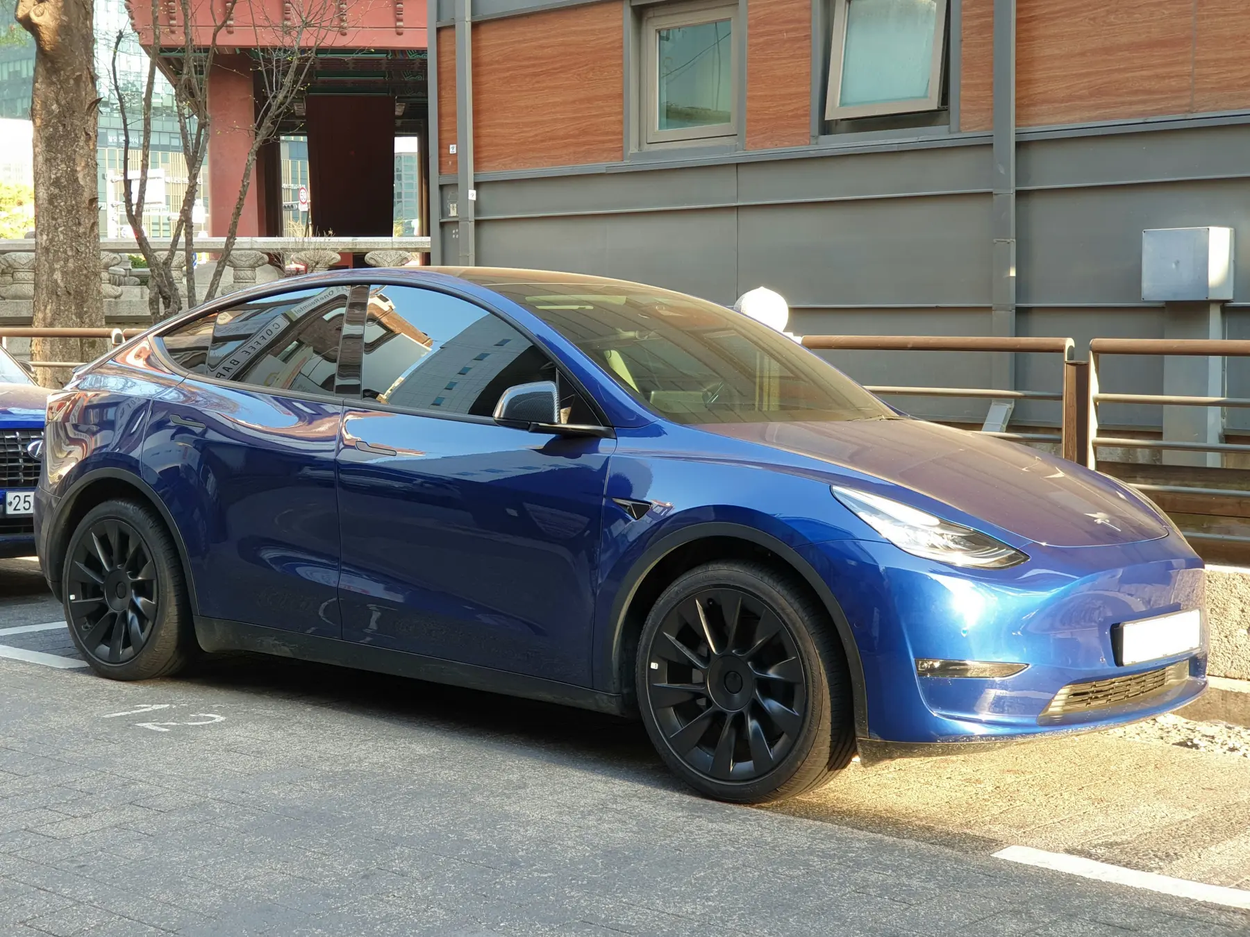 La Tesla Model Y bleue de LCB - TAXI/VTC, garée de trois quarts avant